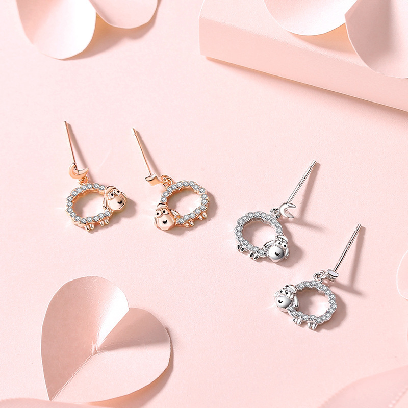Original hollow-out lamb-shaped earrings, made of sterling silver, featuring a delicate and minimalist star and moon design, with tiny cubic zirconia accents