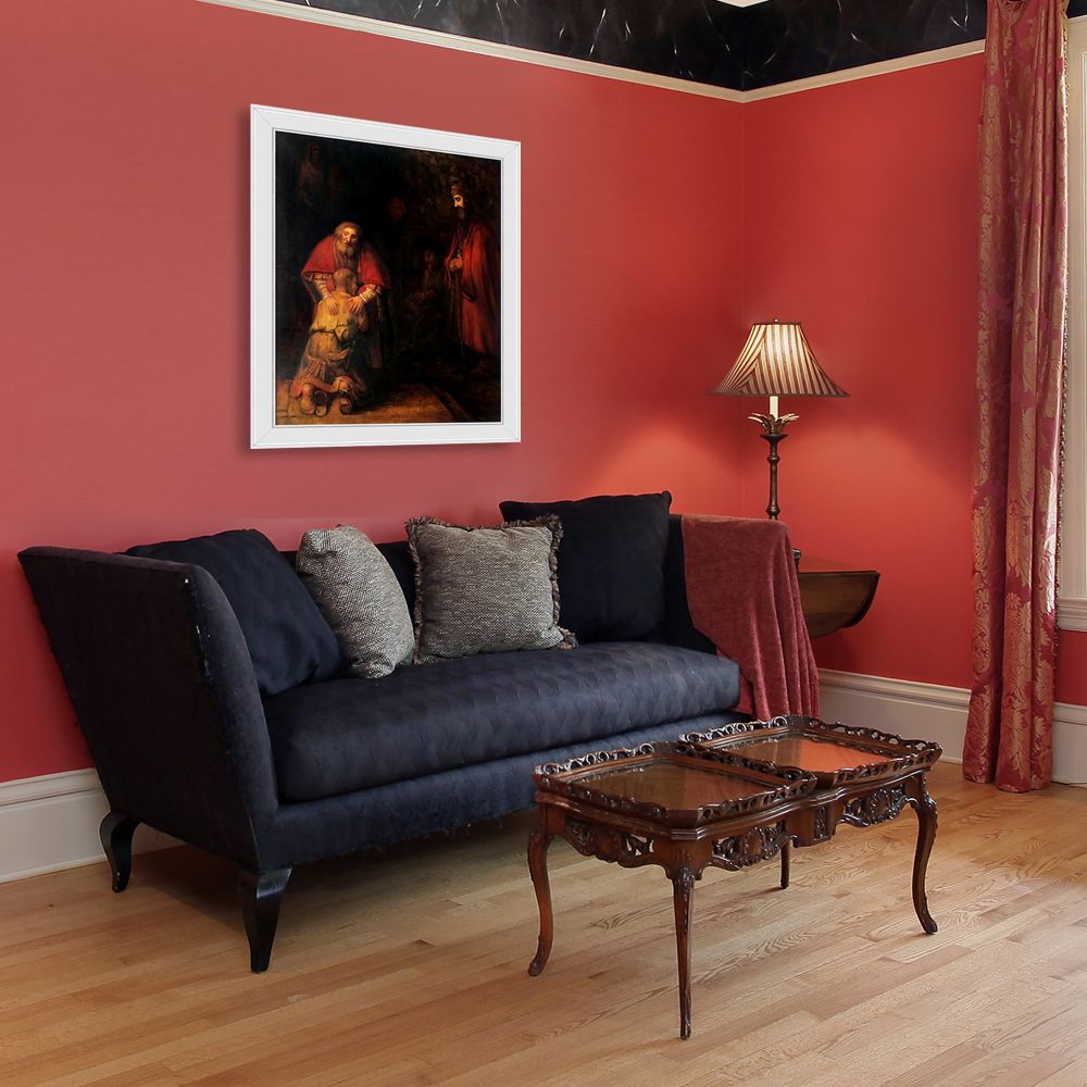 Framed detail of Rembrandt painting on a red wall above a dark blue sofa in a modern living room.